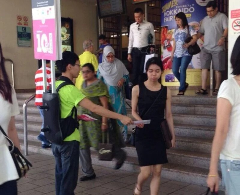 High foot traffic pedestrian crossing in Singapore during peak hours, suitable for flyer distribution jobs and street marketing